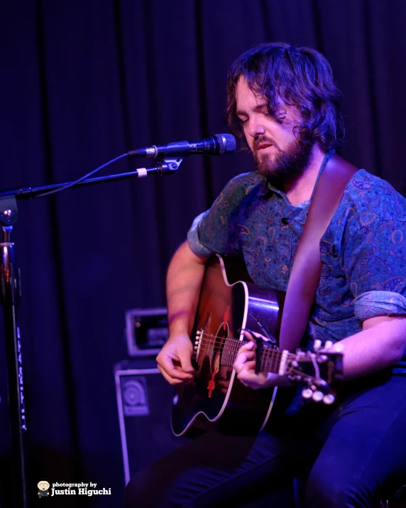 a man that is playing a guitar on stage