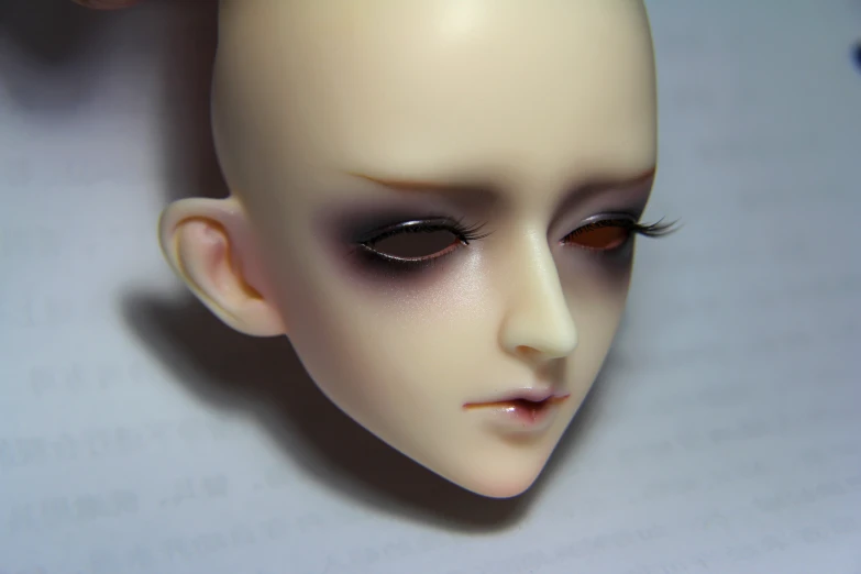 a doll head being painted white for a doll