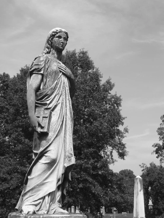 statue of a lady holding a purse in a cemetery