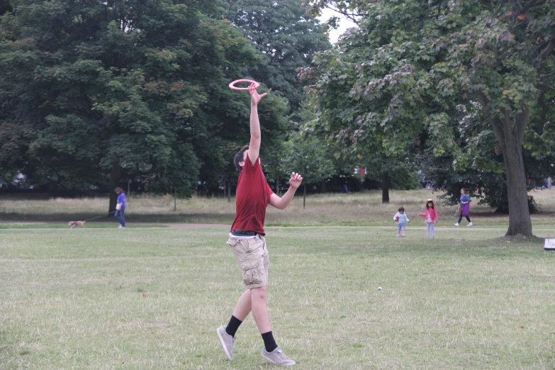 people playing in an open grassy area with trees