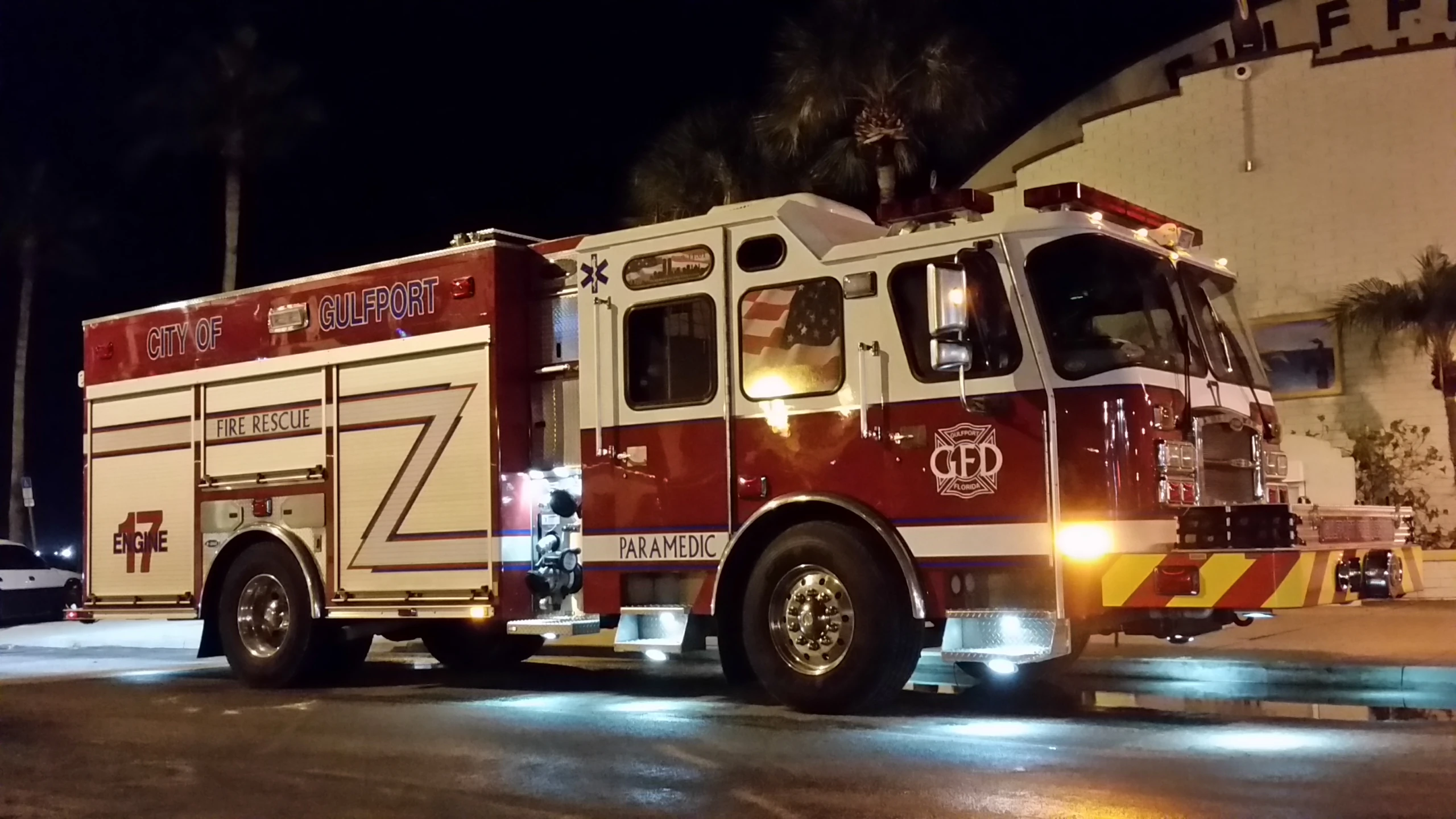 there is a red and white fire truck that is parked by the curb