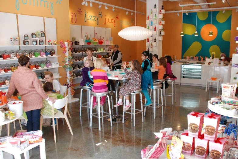 children are eating at the tables in a child's toy store