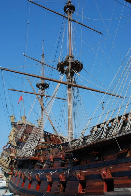 an antique pirate ship with two masts at the dock