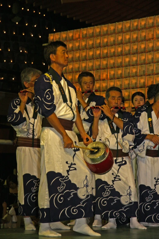 a group of chinese boys playing with a drum