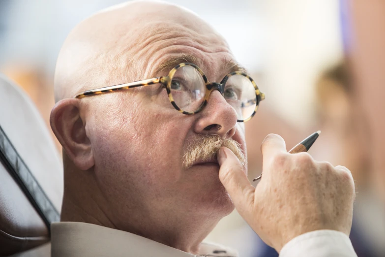 an old man taking his eye contact with his eyeglasses