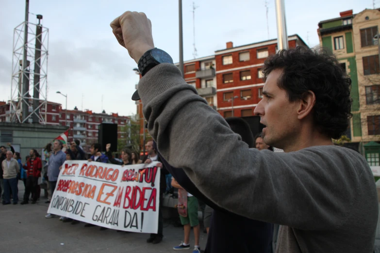 a man holding up a sign in front of a crowd