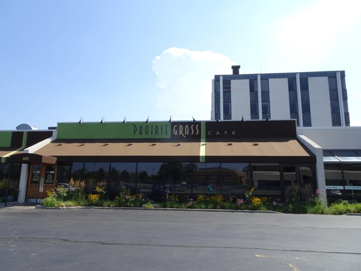 an empty street with a store front and grass