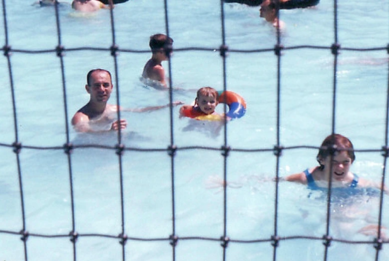 several people playing with ball in large swimming pool