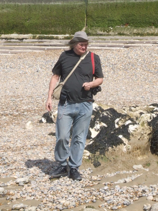 a man holding a red scarf while standing on rocks