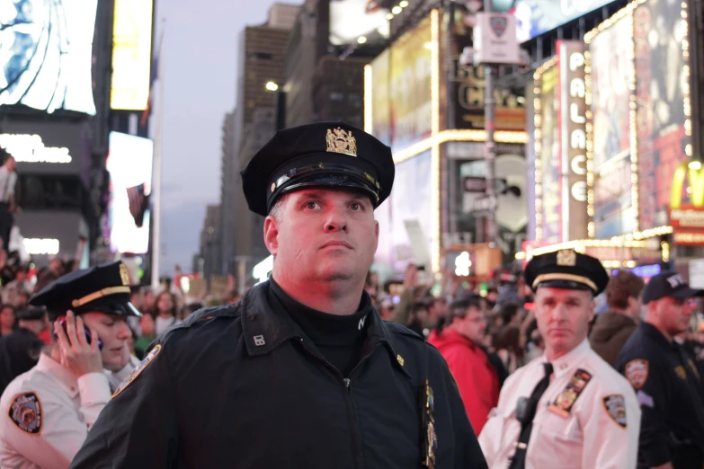 two policemen are standing in front of the crowd