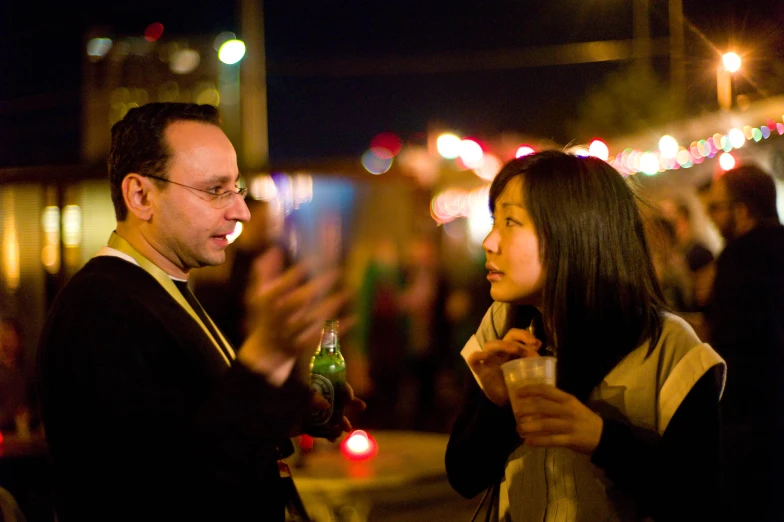 a man and a woman holding drinks at a party