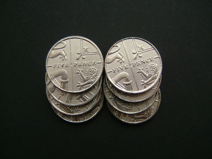 five pieces of silver coin on black surface