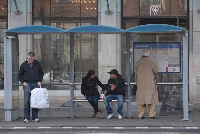 a group of people waiting at a bus stop