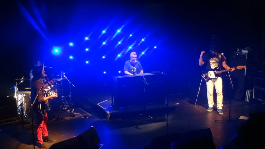 three people standing on stage and playing instruments