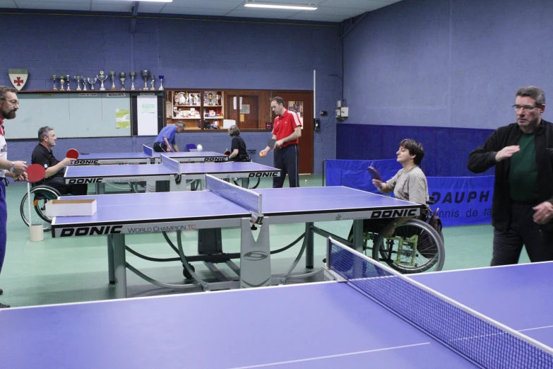 two tables are holding ping pong paddles in an indoor court