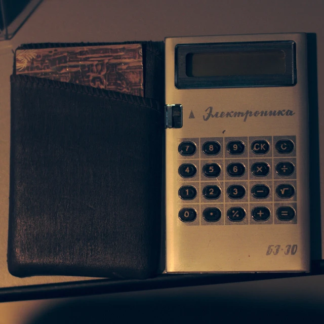 a calculator and wallet laying on a counter