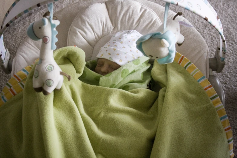 a baby is sleeping in a swing next to the crib