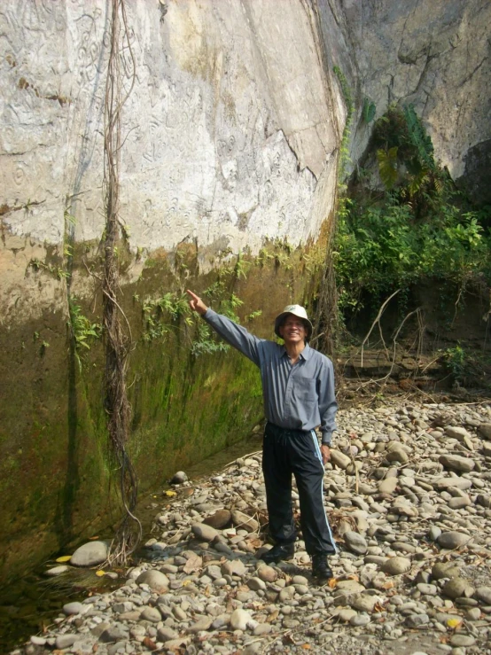 a man standing in front of a big rock