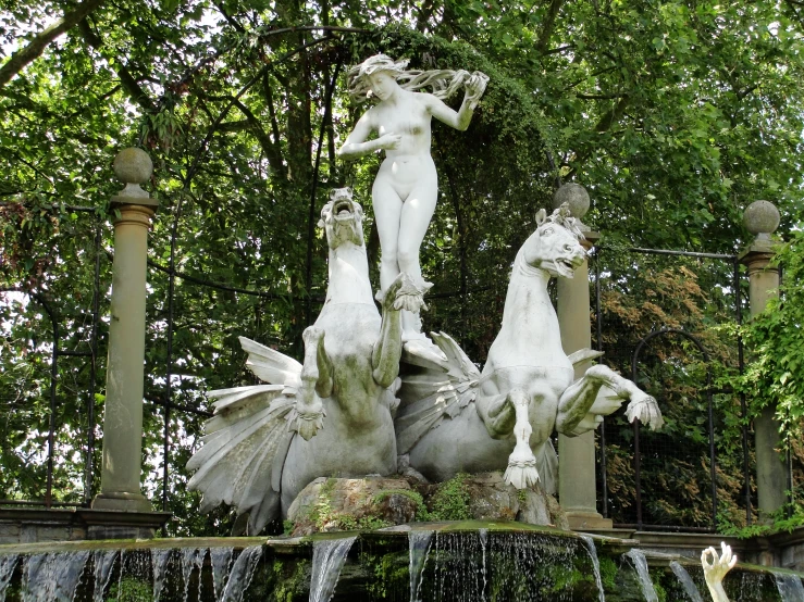 an artful fountain with three statues on it
