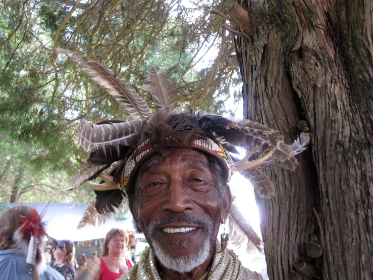 a native american man in a red headdress smiling