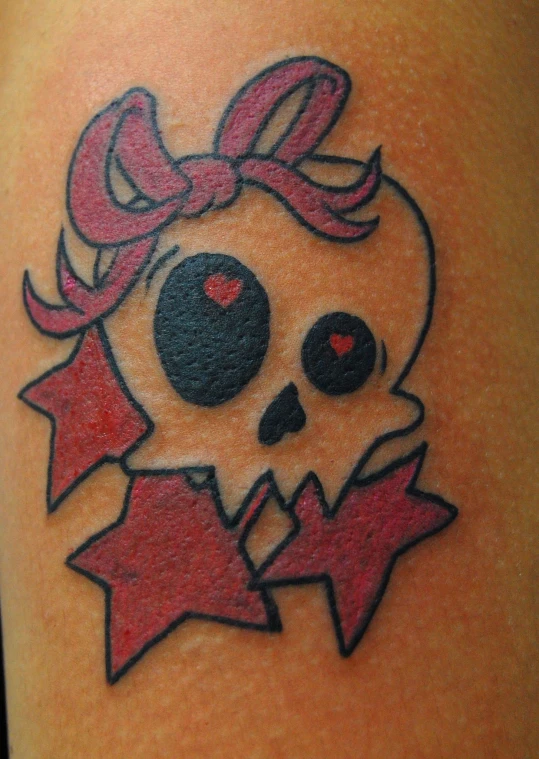 a girl skull with a bow tattoo on her leg