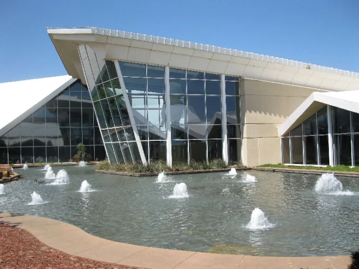 a building with several windows in the corner that features a water fountain