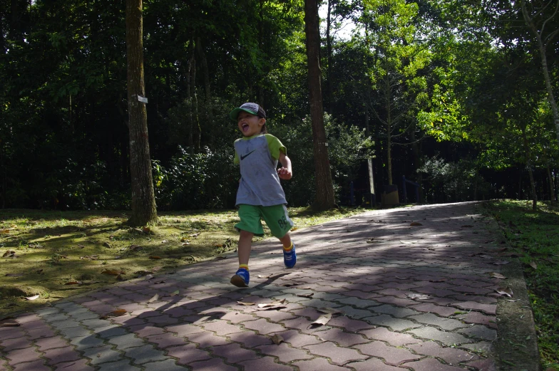 a boy is running with a frisbee on the street