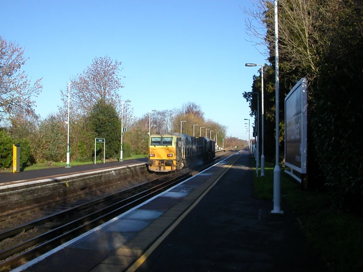 a train sits on the tracks near an empty station