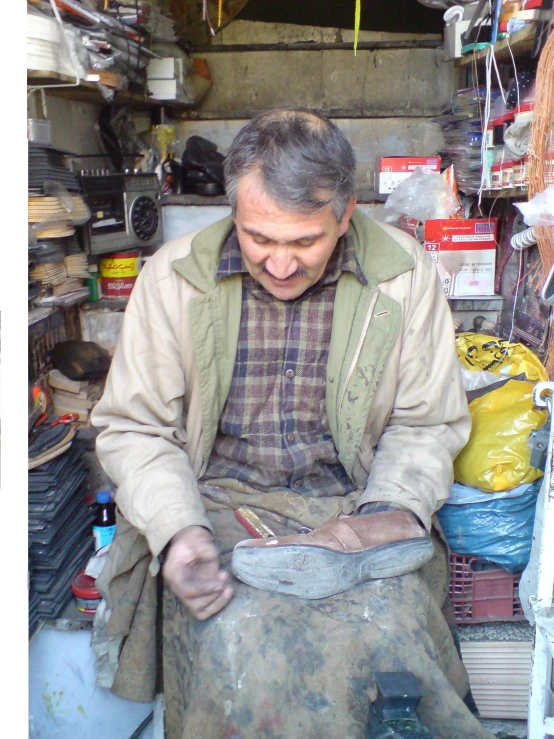 a man sits on the ground while working with a piece of metal