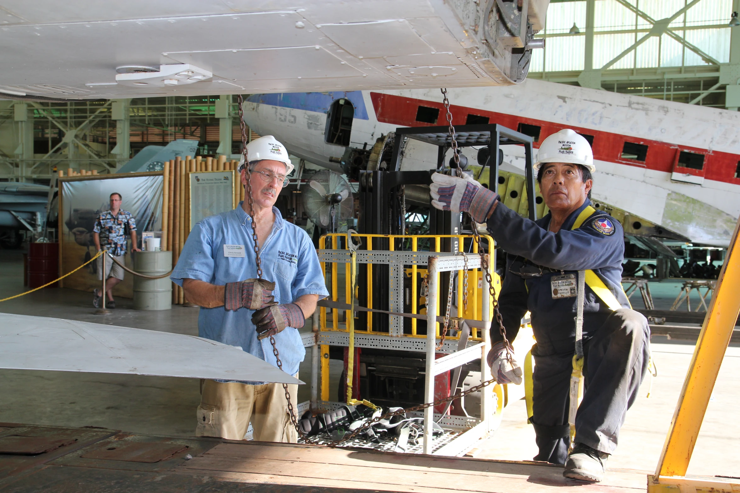 two men standing next to each other in front of a plane