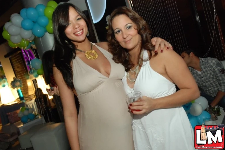 two women pose for the camera at a birthday party