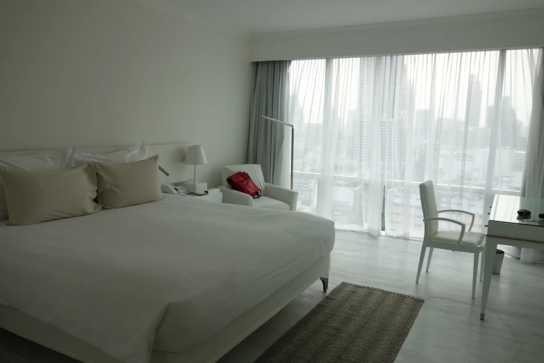 a bed sitting in a bedroom next to two white chairs