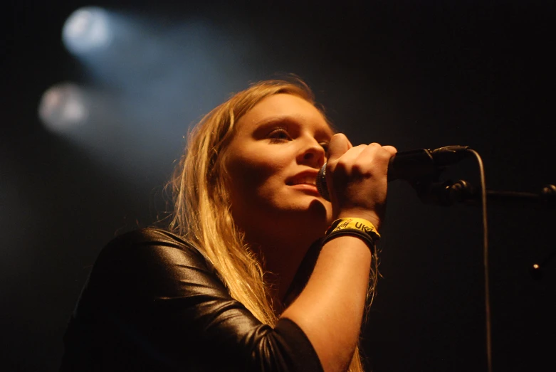 woman with long blonde hair singing on stage