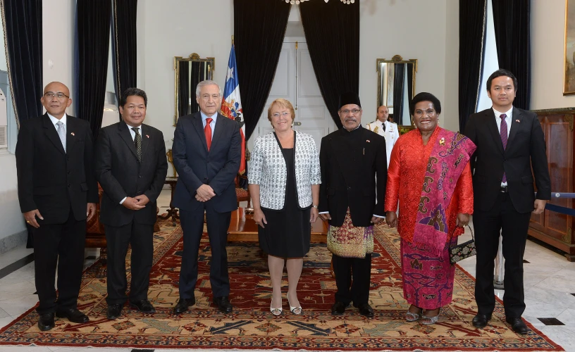 a group of business people standing on a carpet with flags