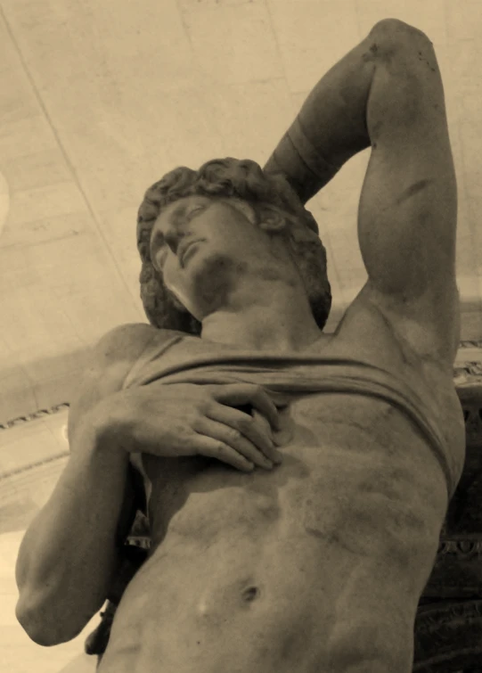 a statue of a young man is shown, possibly in a museum