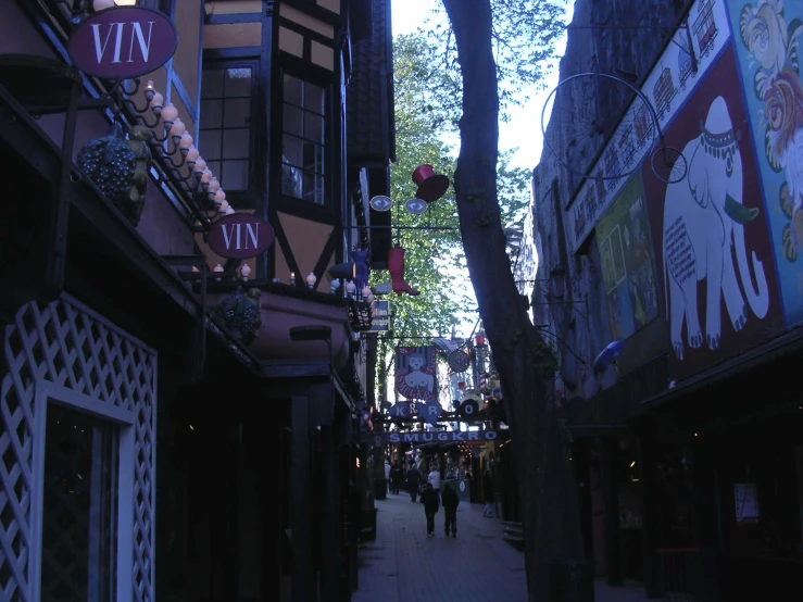 a dark alley way with several stores and people walking