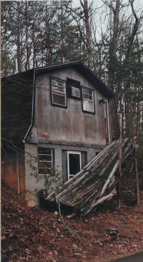 an abandoned shed with a pile of debris sitting outside