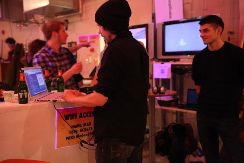 two men stand and look at a computer screen