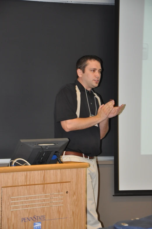 a man is standing up at the podium in front of the screen