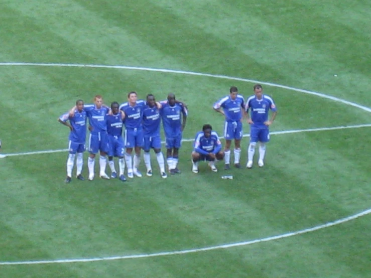 a group of men standing on top of a soccer field