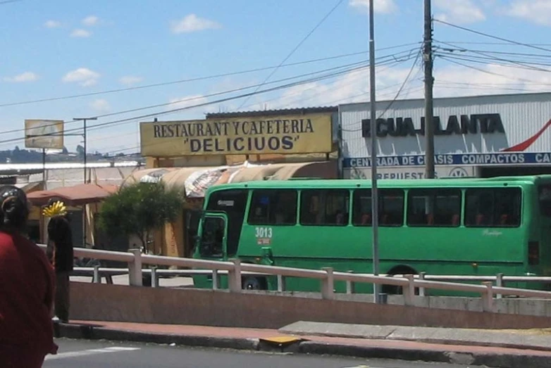 people wait in line to get on the green bus