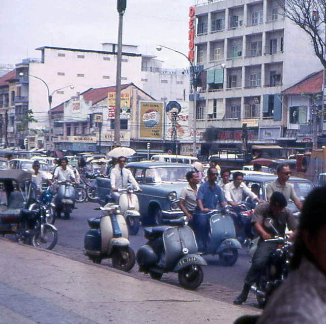 a group of people riding motorcycles down a street