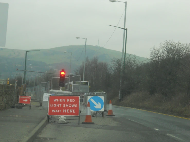 construction signs on a busy road on a foggy day