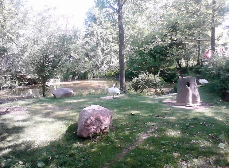 some stones are in a grassy area next to trees