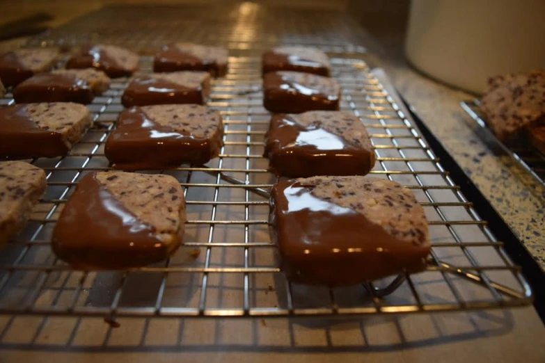 some cookies are on a cooling rack and being iced