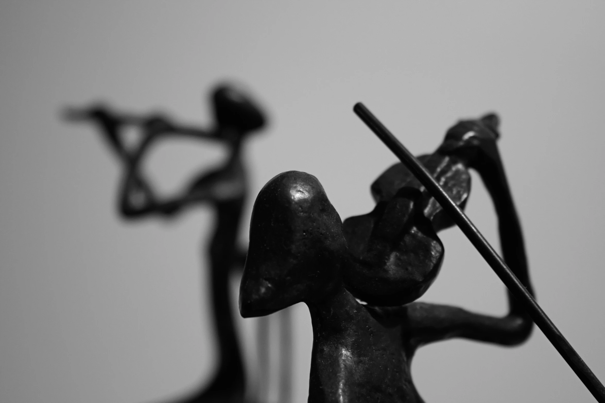 two sculptures of women holding a bow and arrow