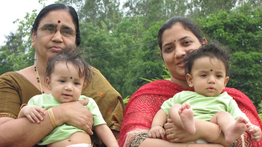 three women holding young children in their hands