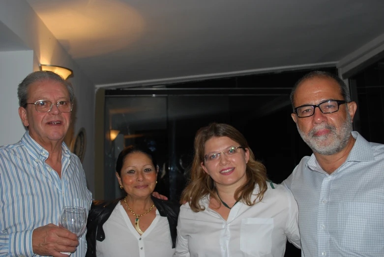 three people are smiling with wine glasses on their necks