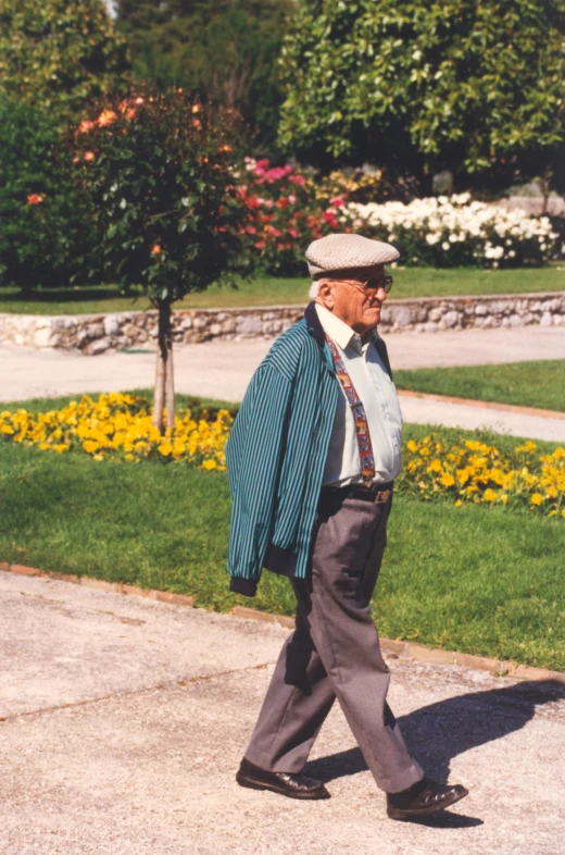 an old man in business clothes walks on the sidewalk