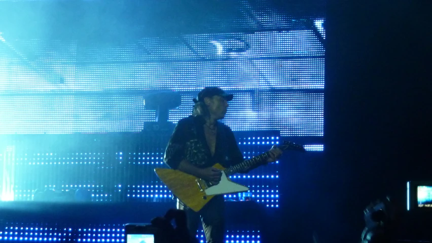 one man is playing guitar on stage with a woman watching